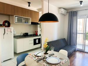 a kitchen and living room with a table and chairs at AP Smart Quirino in Campinas