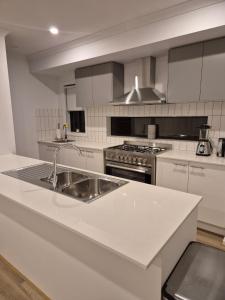 a kitchen with a sink and a stove at Cosy Home in Melton South in Melton South