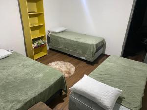 um quarto com duas camas e uma estante de livros em Alquiler en Piriapolis em Piriápolis