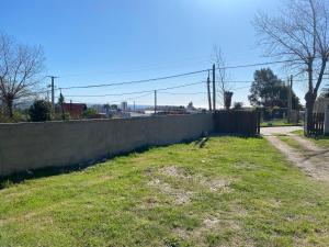 uma parede de retenção num quintal ao lado de uma cerca em Alquiler en Piriapolis em Piriápolis