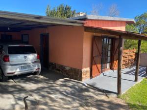 um carro estacionado em frente a uma pequena casa em Alquiler en Piriapolis em Piriápolis