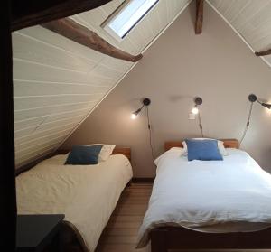 2 Betten in einem Dachzimmer mit 2 Lampen in der Unterkunft Les Gites Accromagnon, Climatisation in Les Eyzies-de-Tayac + 38 Fotos