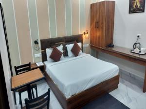 Schlafzimmer mit einem Bett und einem Schreibtisch mit einem Tisch in der Unterkunft Murthal Green Plaza Hotel in Sonīpat