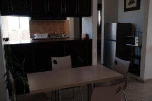 a kitchen with a table and chairs and a refrigerator at apart-hotel alessia in Santiago