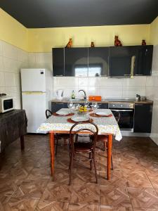 eine Küche mit einem Tisch mit Stühlen und einem Kühlschrank in der Unterkunft Fernanda's House in Ribeira Brava + 2 Fotos