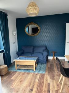 a living room with a blue couch and a table at Chez F & G in Sélestat