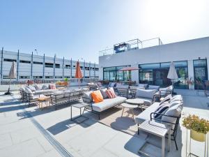 um pátio exterior com sofás, mesas e cadeiras em Canvas Sevilla Lago em Sevilha