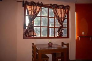 Cette chambre comprend une table et une fenêtre. dans l'établissement Departamento céntrico con terraza, à Mineral de Angangueo