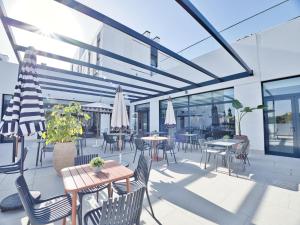 an outdoor patio with tables and chairs and windows at Canvas Sevilla Lago in Seville