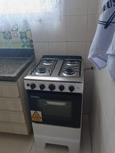 einen schwarzen und weißen Herd in der Küche in der Unterkunft Apartamento com piscina Vista Mar - Mongaguá in Mongaguá