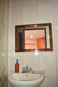 une salle de bain avec un lavabo et un miroir dans l'établissement Departamento céntrico con terraza, à Mineral de Angangueo 8 autres photos