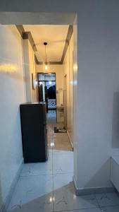 a hallway leading to a kitchen with a refrigerator at La Huésped in Mombasa +7 photos