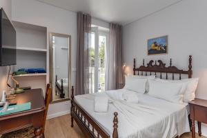 a bedroom with a bed with a desk and a window at BeGuest Estoril Guesthouse in Estoril +101 photos