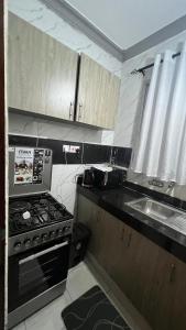 a small kitchen with a stove and a sink at La Huésped in Mombasa