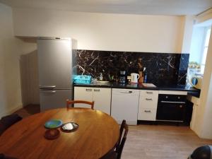 une cuisine avec une table en bois et un réfrigérateur dans l'établissement Chambres Chez Marcel, à Spoy