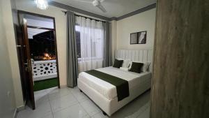 a bedroom with a large bed and a window at La Huésped in Mombasa
