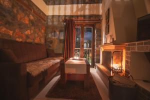 a living room with a couch and a fireplace at ΞΕΝΩΝΑΣ ΘΕΑ in Palaios Agios Athanasios