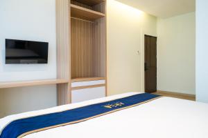 Un dormitorio con una cama y un televisor en una pared. en ARA Stay By ARBA, en Bandung