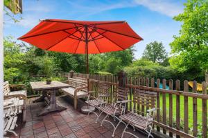 a table and chairs with an umbrella on a patio at Gemütliches Ferienhaus In Tannenberg in Burggen +32 photos