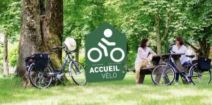 two women standing next to a sign next to bikes at La Chapelle, Les Suites du Palais, l'unique 5 étoiles de Nevers, Suite d'Exception, by PRIMO C0NCIERGERIE in Nevers