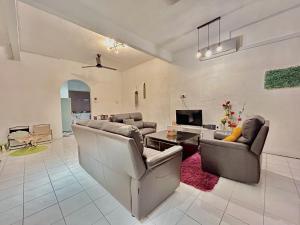 un salon avec deux canapés et une télévision dans l'établissement Cozy 10 Entire House 4 Bedroom At Alma Bukit Mertajam, à Bukit Mertajam