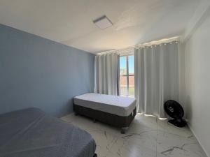 une chambre avec deux lits et une fenêtre dans l'établissement Apartamento 1 quadra do mar em Ipanema - PR, à Pontal do Paraná