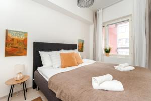 ein Schlafzimmer mit einem großen Bett mit zwei Handtüchern darauf in der Unterkunft Vapari - Tampere Soccer Stadium by Come in! in Tampere