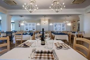 ein Esszimmer mit weißen Tischen und Stühlen in der Unterkunft Ortano Mare Resort in Rio Marina
