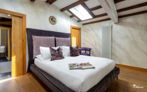 a bedroom with a large bed with a book on it at MURANO Suites - Venezia in Murano