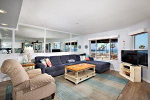 un salon avec un canapé bleu et une télévision dans l'établissement 501P-5 Panoramic Ocean & Pier Views, à Oceanside