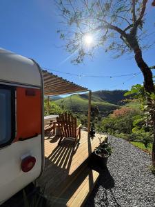 a porch with a table and chairs and a rv at Pousada Sitio Barreirinha in Engenheiro Passos
