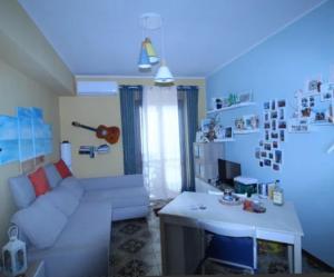 ein Wohnzimmer mit einer weißen Couch und einem Tisch in der Unterkunft La Casa in riva al Mare in Roccalumera