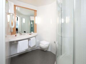 a white bathroom with a toilet and a shower at ibis Genève Centre Nations in Geneva +42 photos