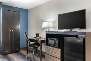 a hotel room with a desk with a tv and a computer at Sleep Inn Indianapolis East in Indianapolis