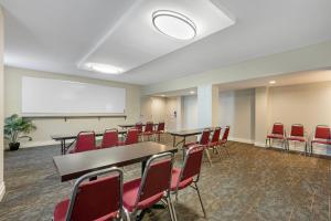a conference room with tables and chairs and a whiteboard at Sleep Inn Indianapolis East in Indianapolis