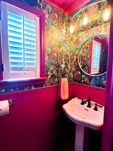 a red bathroom with a sink and a mirror at The Hamilton Harbor House in Oswego