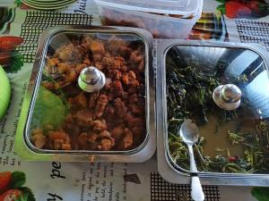 a tray of food on a table with spoons at Fam Wall Homestay in Keruo