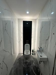Un baño blanco con inodoro y lavabo. en Apartamrnt 1, en Dobrich