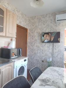 cocina con microondas y mesa con sillas en Apartamrnt 1, en Dobrich