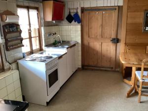 a kitchen with a white stove and a sink at Mannried 2 1 2 Zimmerwohnung Rustikal in Zweisimmen +12 photos