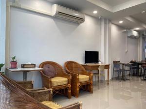 una sala d'attesa con sedie in vimini e TV di Starhouse a Hat Yai