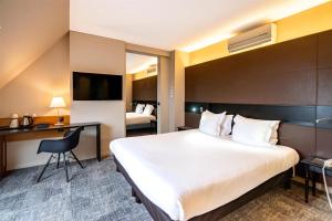 a hotel room with a large bed and a desk at Hotel L'Europe Colmar, BW Signature Collection in Colmar +113 photos
