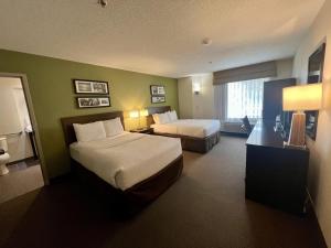a hotel room with two beds and a window at SureStay by Best Western Roseburg in Roseburg