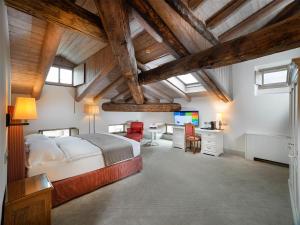 a bedroom with a bed and a desk with a television at Grand Hotel della Posta, WorldHotels Distinctive in Sondrio +111 photos