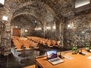 a conference room with a table and a laptop on a desk at Grand Hotel della Posta, WorldHotels Distinctive in Sondrio +110 photos