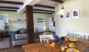eine Küche und ein Wohnzimmer mit einem Holztisch in der Unterkunft Ferienhaus für 3 Personen  2 Kinder ca 60 m in Neuenkirchen, Ostseeküste Deutschland Rügen in Neuenkirchen + 32 Fotos