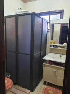 ein Badezimmer mit Dusche, Waschbecken und Spiegel in der Unterkunft Sítio do Berger in São Gabriel