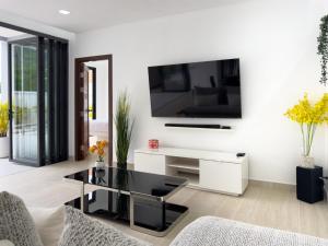 un soggiorno con tavolo nero e TV a parete di Stylish 3BR Pool Villa Lawan Villa (LWV1) a Ban Na Bon