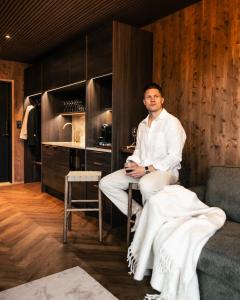 Un homme assis sur une table dans une pièce dans l'établissement SkyView Igloo Resort, à Rovaniemi