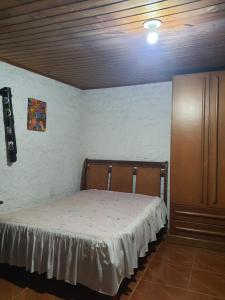 ein Schlafzimmer mit einem Bett und einer Kommode in einem Zimmer in der Unterkunft Sítio do Berger in São Gabriel